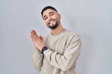 Genç yakışıklı adam izole edilmiş arka planda ayakta alkışlıyor ve mutlu, neşeli ve gururlu elleri alkışlıyor. 