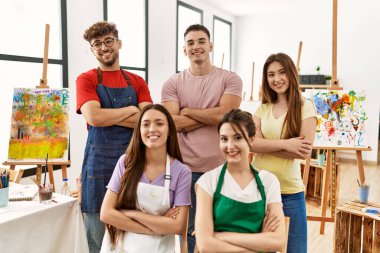 Group of five hispanic artists at art studio happy face smiling with crossed arms looking at the camera. positive person. 