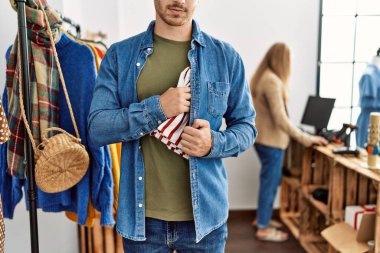 Genç İspanyol soyguncu elbise dükkanından gömlek çalıyor..