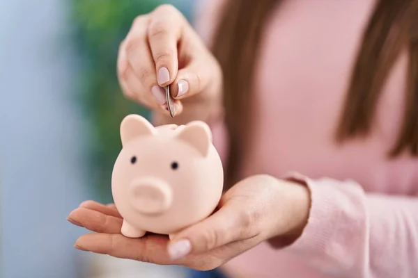 Young Woman Inserting Coin Piggy Bank Home — Foto Stock