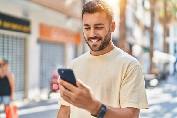 Junger Hispanischer Mann Lächelt Selbstbewusst Mit Smartphone Auf Der Straße — Stockfoto