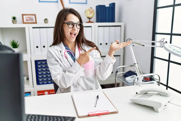 Joven Doctora Vistiendo Uniforme Médico Estetoscopio Clínica Sorprendida Sonriendo Cámara — Foto de Stock