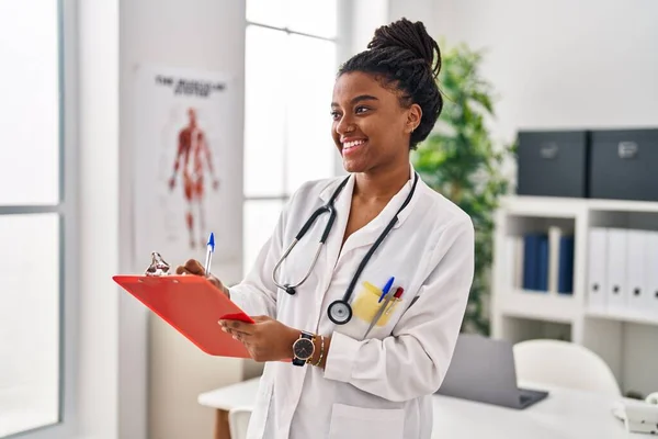 African American Woman Wearing Doctor Uniform Writing Document Clinic — Stockfoto