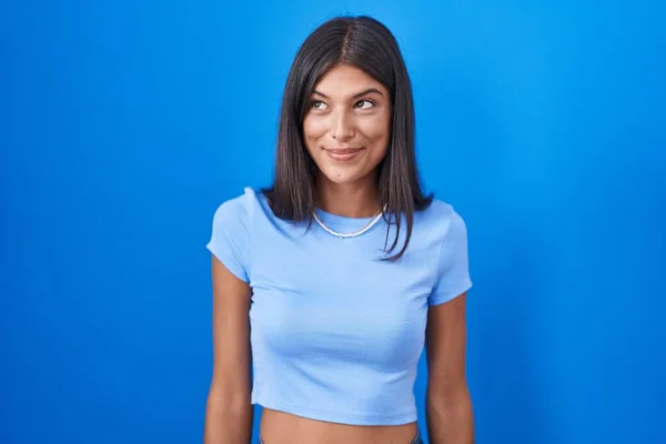 Brunette Young Woman Standing Blue Background Smiling Looking Side Staring — Fotografia de Stock