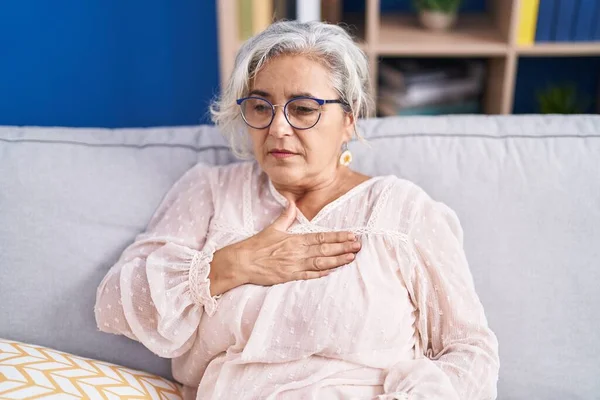 Siwowłosa Kobieta Średnim Wieku Siedząca Kanapie Cierpiąca Atak Serca Domu — Zdjęcie stockowe