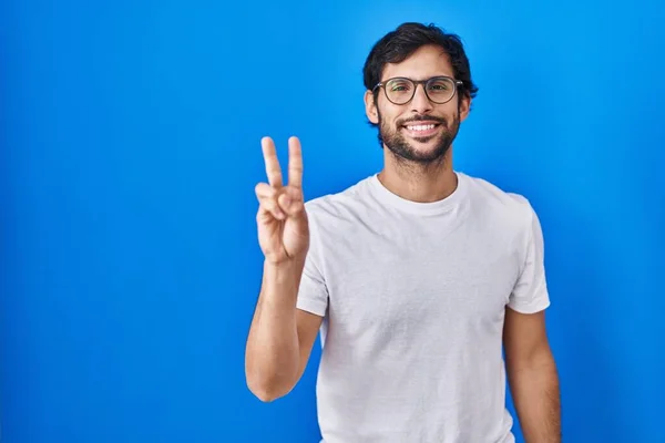 Handsome Latin Man Standing Blue Background Showing Pointing Fingers Number — Stockfoto