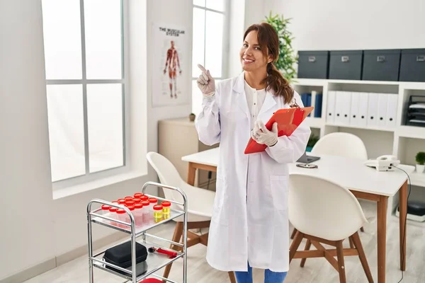 Hispanic Doctor Woman Doing Urine Tests Clinic Smiling Happy Pointing — Stok fotoğraf