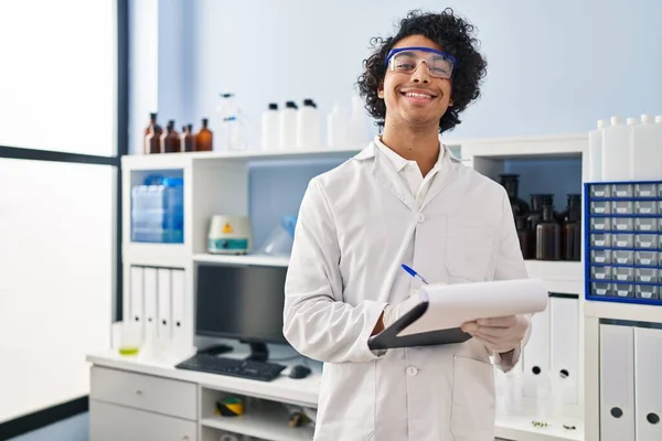 Mladý Hispánec Muž Nosí Vědec Uniformu Psaní Podložce Laboratoři — Stock fotografie