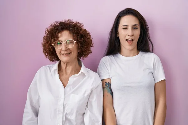 Hispanic Mother Daughter Wearing Casual White Shirt Pink Background Winking — Stock Photo, Image