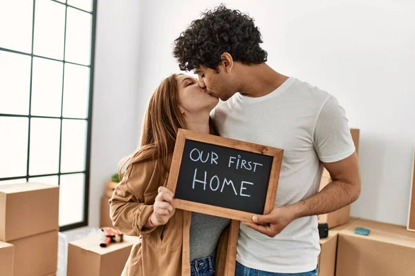 若いカップル笑顔幸せな保持黒板で私たちの最初のホームメッセージで新しい家 — ストック写真