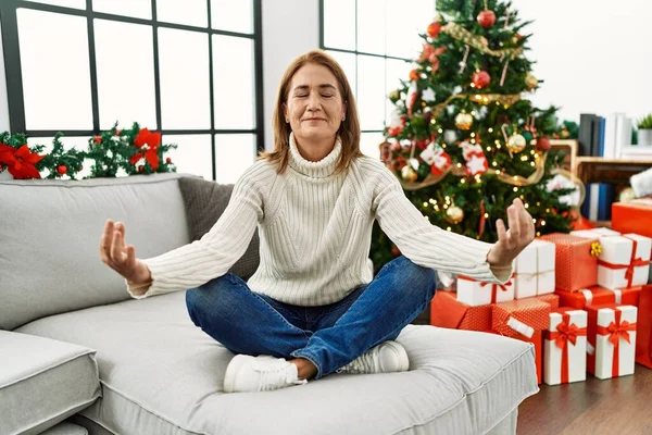 Medelålders Kaukasiska Kvinna Som Gör Yoga Motion Sittandes Vid Julgranen — Stockfoto