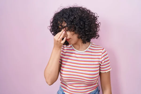 年轻的中东女人站在粉红的背景上 疲惫地揉揉着鼻子和眼睛 感到疲倦和头痛 压力和挫败感概念 — 图库照片