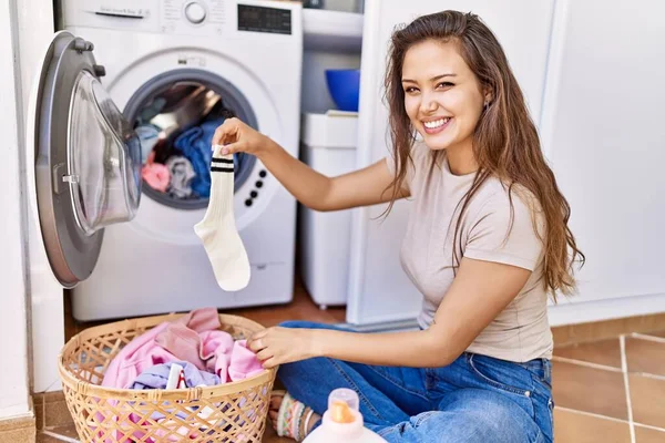 年轻的惊慌失措的女孩高兴地在家里拿着干净的衣服在洗衣机前洗澡 — 图库照片