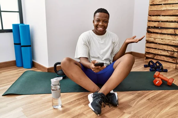 Young African Man Sitting Training Mat Gym Using Smartphone Smiling — Stok fotoğraf