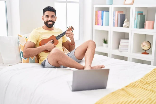 Jonge Arabisch Man Met Online Ukelele Les Zitten Bed Slaapkamer — Stockfoto