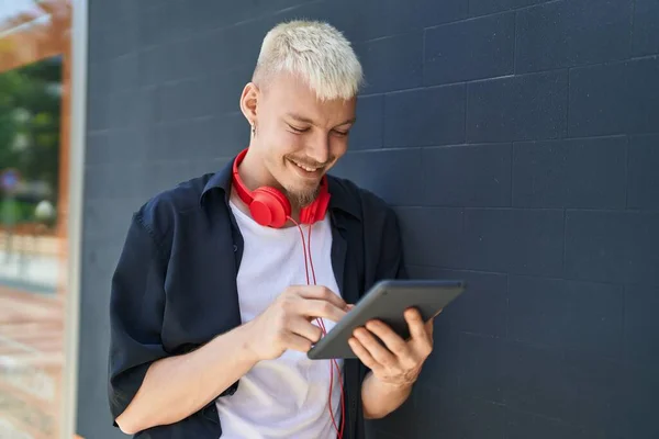 Young Caucasian Man Using Touchpad Wearing Headphones Street —  Fotos de Stock