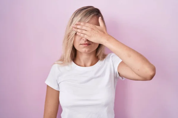 Young Blonde Woman Standing Pink Background Covering Eyes Hand Looking — Photo