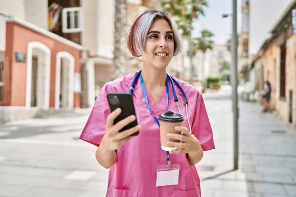 年轻的高加索医生妇女在城市里喝咖啡和使用智能手机 — 图库照片
