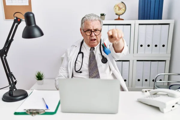 Senior Kaukasier Man Bär Läkare Uniform Och Stetoskop Kliniken Pekar — Stockfoto