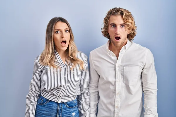 Young Couple Standing Blue Background Shock Face Looking Skeptical Sarcastic — Stock fotografie