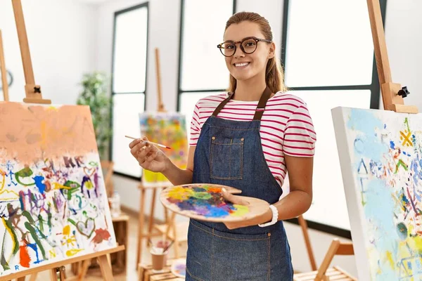 Mujer Joven Sonriendo Confiada Sosteniendo Pincel Paleta Estudio Arte — Foto de Stock