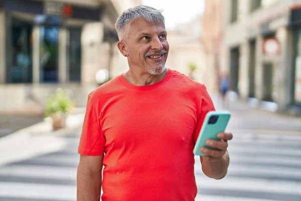 Homem Cabelos Grisalhos Meia Idade Sorrindo Confiante Usando Smartphone Rua — Fotografia de Stock