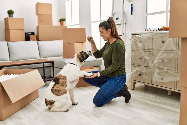 Молодая женщина обучает собаку дома