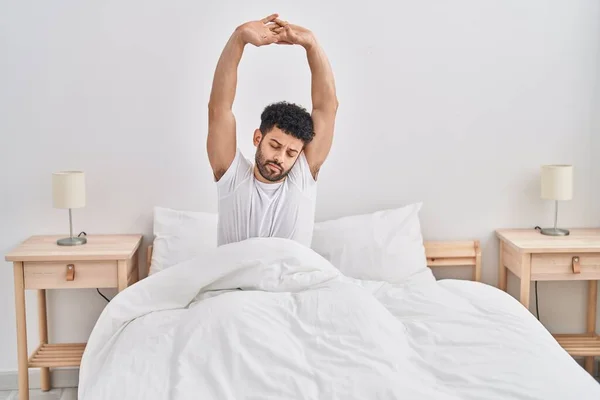 Young Arab Man Waking Stretching Arms Bedroom — стоковое фото