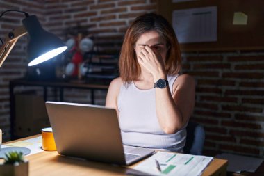 Geceleri ofiste çalışan esmer bir kadın. Burnu ve gözleri ovuşturmaktan yorgun. Yorgunluk ve baş ağrısı çekiyor. Stres ve hüsran kavramı. 