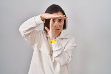 Orta yaşlı İspanyol bir kadın izole edilmiş geçmişinin başında duruyor. Elleriyle jest yapıyor, hayal kırıklığına uğramış ve ciddi bir yüz ifadesi var. 