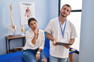 Young hispanic woman at physiotherapist appointment looking sleepy and tired, exhausted for fatigue and hangover, lazy eyes in the morning. 