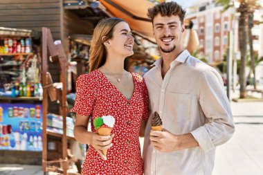 Genç İspanyol çift gülümsüyor, şehirde dondurma yiyorlar..