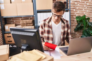 Young man ecommerce business worker using laptop and touchpad working at office