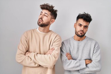 Young homosexual couple standing over white background looking sleepy and tired, exhausted for fatigue and hangover, lazy eyes in the morning. 