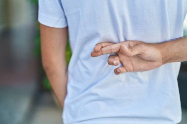 Sokakta parmakları çapraz duran İspanyol genç adam.