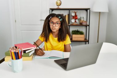 Genç Afro-Amerikan kız evde ödevini yapıyor ve canlı yayında öpüşürken kameraya bakıyor. Sevimli ve seksi. aşk ifadesi. 