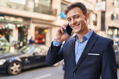 Young man business worker smiling confident talking on smartphone at street
