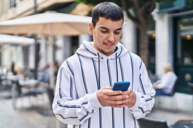 Sokakta akıllı telefon kullanan kendine güvenen genç adam.