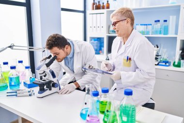 Mother and son scientist partners working at laboratory