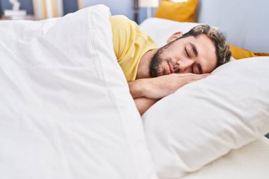 Young man lying on bed sleeping at bedroom