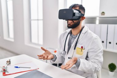 Genç İspanyol doktor klinikte sanal gerçeklik gözlüğü kullanıyor.