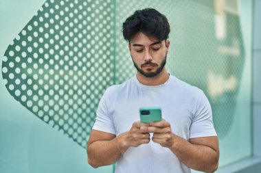 Sokakta akıllı telefon kullanan genç bir İspanyol.