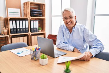 Ofiste çalışan orta yaşlı erkek ve kadın işçiler.