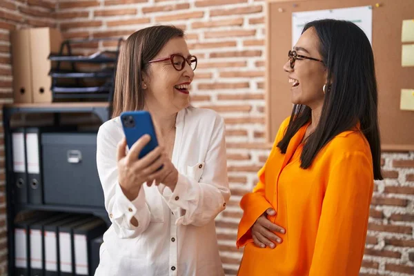 Two Women Business Workers Using Smartphone Working Office — Foto Stock