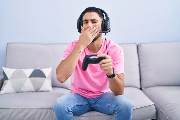 Joven Hispano Jugando Videojuego Sosteniendo Controlador Sentado Sofá Aburrido Bostezo —  Fotos de Stock