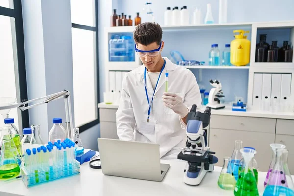 Jovem Hispânico Vestindo Uniforme Cientista Usando Laptop Segurando Tubo Teste — Fotografia de Stock