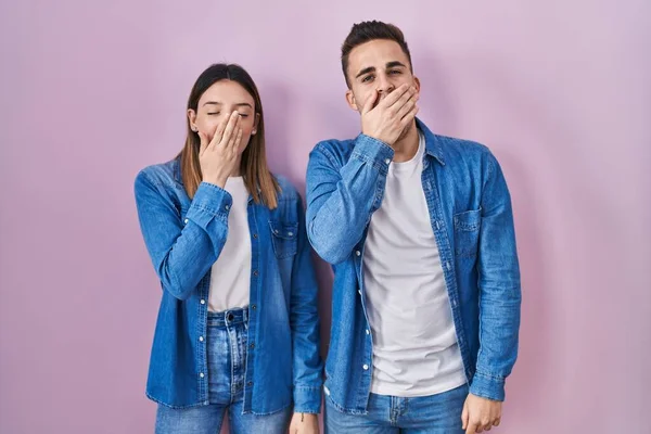 Young Hispanic Couple Standing Pink Background Bored Yawning Tired Covering — Stockfoto