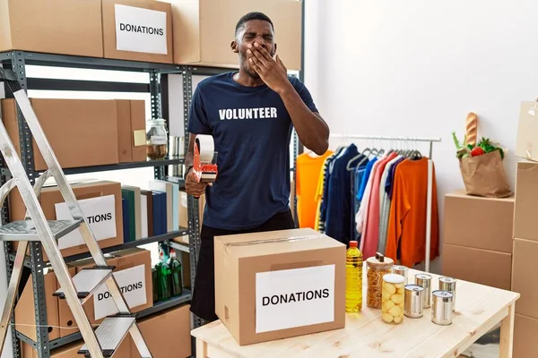 Young African American Volunteer Man Packing Donations Box Charity Bored — Stock Photo, Image