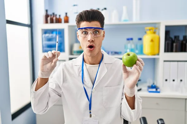 Jovem Hispânico Trabalhando Laboratório Cientistas Segurando Maçã Com Medo Chocado — Fotografia de Stock