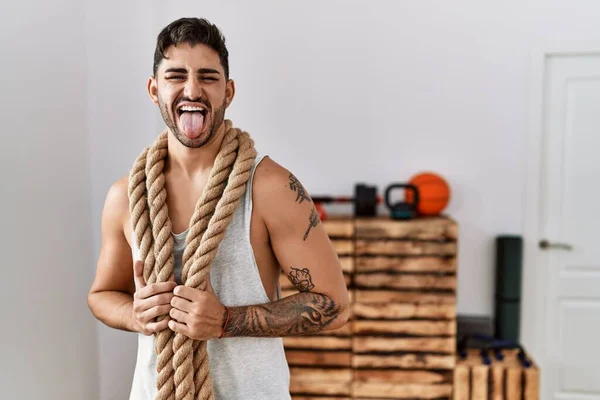 Young Hispanic Man Training Battle Rope Gym Sticking Tongue Out — Stockfoto